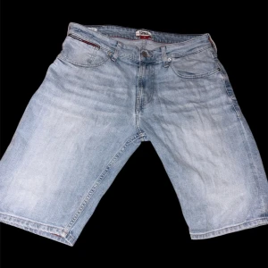Ljusblå jeansshorts Tommy Jeans - Säljer ett par ljusblå jeansshorts från Tommy Jeans, modell Ronnie Relaxed Short. Klassisk femficksdesign, normal passform och snygga detaljer med logga bak. Perfekta för en chill sommarstil.