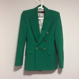 Gorgeous Zara blazer in a striking emerald green. - Heavy, structured fabric that feels luxurious and high quality. Features classic shoulder pads for a flattering, tailored silhouette and gold-tone buttons for a chic finish. Perfect for both office wear and dressed-up evenings.  🪡 Condition: New without tags 🎯 Fit: True to size, structured cut 💚 Colour: Emerald green  A timeless piece that instantly elevates any outfit.