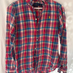 Rutig skjorta från Ralph Lauren - rutig skjorta från Ralph Lauren i klassisk passform. Skjortan har långa ärmar, knappar framtill och broderad logga på bröstet. Tillverkad i mjuk bomull.