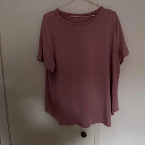 Ljusrosa loose t-shirt i mjuk bomull - Säljer en ljusrosa t-shirt med loose passform och rund hals. Slits på varsin sida och längre bak. Perfekt för dig som gillar enkel och stilren design med lite oversized känsla.