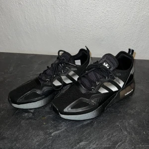 Adidas Originals ZX 2K Boost - Säljer Adidas Originals ZX 2K Boost. Svarta med silvriga detaljer. Sköna skor för träning och vardag. Storlek 40 2/3. Pris kan diskuteras vid snabb affär 