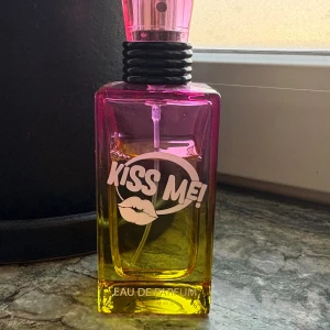 Kiss Me! Eau de Parfum 50ml - Färgstark och lekfull parfym med cool design. 50 ml flaska, tillverkad av Coscentra. Perfekt för dig som vill sticka ut och sprida good vibes. Tillverkad i Kina. Köpt den på H&M, doften passar ej mig. Den passar till yngre 