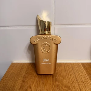 Casamorati Lira Eau de Parfum - Casamorati Lira Eau de Parfum kommer i en lyxig flaska med guldton. Perfekt för dig som vill sticka ut med en exklusiv doft. Snygg design som passar på hyllan och i väskan.