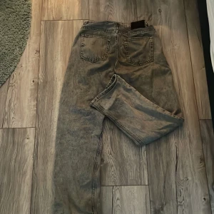 Grå jeans från Grunt, storlek 27 - Säljer ett par grå jeans från Grunt i modellen 'Hannah Ash Grey'. Jeansen har klassisk femficksdesign, raka ben och normal passform. Färgen är askgrå med en tvättad look som ger en cool vibe. Perfekta till vardags med en hoodie eller t-shirt.