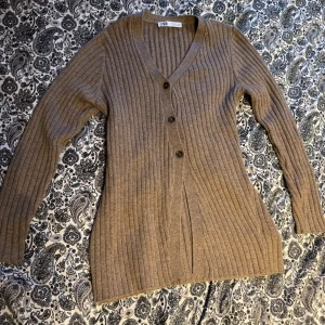 Ribbad beige kofta från Zara - Säljer en beige ribbad kofta från Zara i storlek M. Koftan har v-ringning, tre knappar framtill och långa ärmar. Materialet är stickat och ger en skön och mjuk känsla. Perfekt för lager-på-lager och chill stil. Sitter bra på de som bär storlek S med. Fler bilder? Skriv så fixar jag🌸