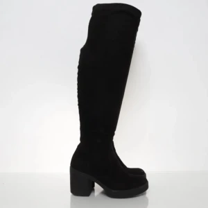 Svarta overknee stövlar med klack - Snygga svarta overknee stövlar i mocka-look med chunky klack och platt sula. Stövlarna har en stilren design och går högt upp över knäet, perfekt till kjol eller klänning. Klassisk rund tå och diskret snörning baktill för bättre passform.