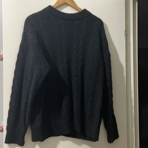 Svart tröja - Fick den som present av morfar men var nog lite stor för min del. Mysig svart kabelstickad tröja med grov ribbad krage och långa ärmar. Tröjan har ett klassiskt flätmönster och är perfekt för kyliga dagar. Passformen är lite loose och den är enkel att matcha med jeans eller kjol.  Kan lätt gå ner i pris mycket 500 är bara max