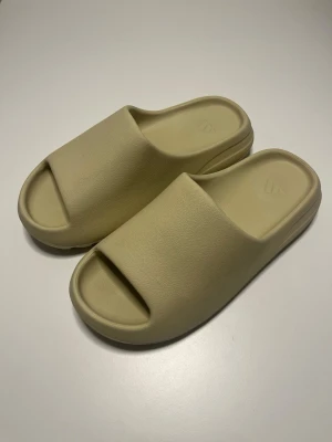 Adidas Yeezy Slide Beige - Säljer ett par Adidas Yeezy Slide i beige färg.