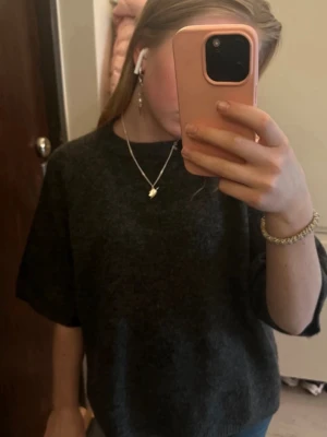 Mörkgrå stickad t-shirt  - Säljer en mörkgrå stickad t-shirt från lager 157 i storlek XS. Materialet är mjukt och stickat.