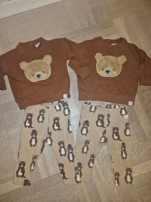 Supersöta sett med nallar från Lindex, storlek 68 - Supergulliga bruna sett från Lindex med ett mjukt, fluffigt nallehuvud framtill. Tröjan  har rund hals och ribbade muddar. Nallehuvudet är broderat och har små detaljer i beige och orange. Perfekt för att ge en mysig look till de minsta. Med matchande leggings till. Storlek 68.                                                                   Två sett ingår enligt bilder.                                      Mycket fint skick.                                  Djur rökfritt hem