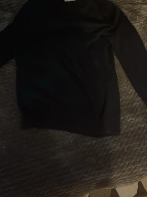 Mörkblå långärmad tröja - En enkel mörkblå långärmad tröja med rund hals. Perfekt för att bygga lager eller ha som basplagg. Tröjan har en klassisk passform och är gjord i ett mjukt material som känns skönt mot huden.