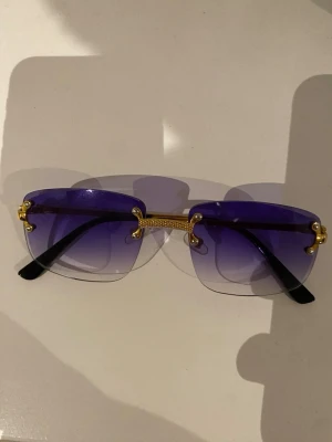 Lila Solglasögon  - Detta är Kachawoo kantlösa solglasögon med fyrkantig lila toning och gulddetaljer. Köpta för 350