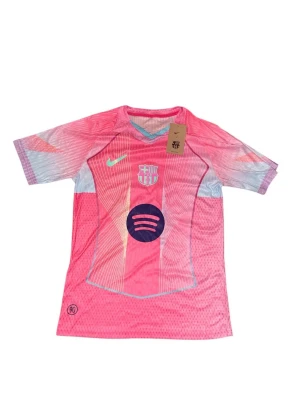 Barcelona tröja - Bilderna visar en rosa FC Barcelona fotbollströja med Pedri och nummer 8 på ryggen, Nike-logga och Spotify sponsor på framsidan. Tröjan har mönstrade detaljer i ljusblått och vitt.