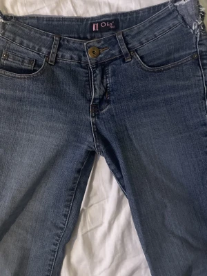 Blå bootcut jeans från Olin - snygga lågmidjade bootcut jeans! de är utsydda i midjan och slitna nertill, därav priset!