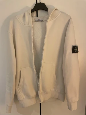 Stone island hoodie  - Vit Stone island zip hoodie i storlek S. Säljer så billigt pågrund av att dragkedjan är trasig. Kom med bud!