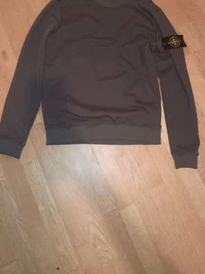 Mörkgrå tröja från Stone Island - Säljer en mörkgrå långärmad tröja från Stone Island,             Storlek S, Använd endast ett fåtal gånger.