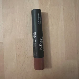 Isadora Lip Desire Sculpting Lipstick - Isadora Lip Desire Sculpting Lipstick i färgen 56 Rosewood. Läppstiftet har en snygg brunrosa ton och kommer i en stilren svart hylsa med brunt lock. Perfekt för att skapa fylliga och definierade läppar med krämig finish. Aldrig använd, men jag råkade skrapa toppen mot locket nu när jag skulle kolla så att allt var ok med den. Se bild. 