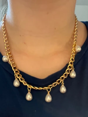 Guld halsband  -  Ett guldigt halsband med vita pärlor på som är handgjort 