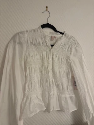 Vit blus nelly - Säljer en helt ny vit blus från Nelly. Den har prislappen kvar. Säljer då den inte passar mig. Har även en i svart