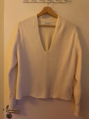 Vit ribbad stickad tröja Wera (S) - Säljer en vit stickad tröja från Wera i storlek S. Tröjan har djup v-ringning, ribbad struktur och långa ärmar. Perfekt för lager-på-lager och har en clean, modern look. Materialet är mjukt och ger en skön känsla mot huden. Tung och lyxig känsla i materialet. 