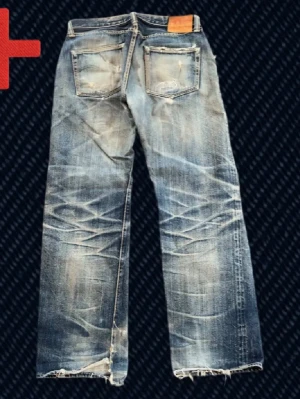 Vintage Archive Japanska Selvedge jeans - Ett par vintage Japanska Selvedge Jeans från märket The Flat head! Storlek på taggen: 33 (se mått nedan!). Fint skick, har blivit lagade till stor del men finns några mindre olagade slitningar kvar som t.ex heelbite. Skriv om du har frågor!  Mått: Storlek på tag – 33, Midja – 40 cm, Lår – 30 cm, Innersöm – 77 cm, Längd – 102 cm, Benöppning – 23.5 cm