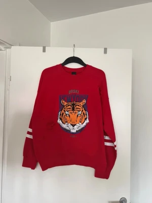 Tröja med tryck röd  - Storlek L. Aldrig använd. 