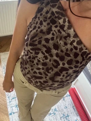 Leopardmönstrad oneshoulder topp - Säljer en snygg leopardmönstrad topp med oneshoulder-design och bred axelrem. Toppen har en tight passform och är tillverkad i ett mjukt, stretchigt material som sitter skönt mot kroppen. Perfekt för dig som vill sticka ut med ett djurmönster.