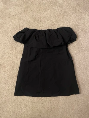 Svart offshoulder klänning & Other Stories - Supersnygg svart kortklänning från & Other Stories med offshoulder-modell och volang upptill. Klänningen har en rak passform och är gjord i ett mjukt tyg som känns skönt mot huden. Perfekt för dig som vill ha en enkel men trendig look. Nytt pris 600, säljer för 300 då jag har använt den 2 gånger