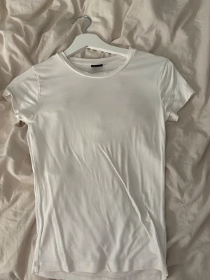 Vit T-shirt - Säljer denna jättefina tajta t-shirten ifrån Gina som är perfekt för många tillfällen🤍