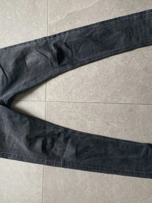 Svarta slim fit Dondup jeans - Jag säljer ett par svarta Donda jeans  skinny fit men käns som slim fit, har gått sönder i skrevet men syns lite när man har på sig dem. Pris kan diskuteras 