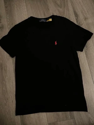 Svart Polo Ralph Lauren T-shirt  - Tjena, säljer denna stilrena och helt nya Polo Ralph Lauren T-shirt med storleken S men passar som XS. Skriv gärna vid intresse! 