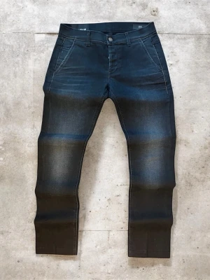 Svarta Dondup Konor jeans med fade, storlek 30 - Svarta Dondup jeans med fade i modellen Konor skinny Fit med ren och modern design. En stilren skinny fit-silhuett som ger ett skarpt och tidlöst uttryck, lätt att bära både till vardag och mer uppklädda outfits.  Jeansen är i mycket bra skick, sparsamt använda och helt utan defekter. Tillverkade i 90 % bomull och 10 % elastan  Storlek: 30  Mått: 1/2 midja: 39 cm Längd: 103 cm Lårbredd: 26 cm Benöppning: 16 cm