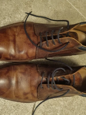 Bruna kängor från Lloyd i skinn - Bruna kängor från Lloyd med klassisk snörning. Inte mycket använda. Några små märke dock, därav priset. Storlek 8,5 vilket ska motsvara 42,5.