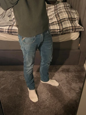 Replay Anbass blå jeans 30/30 - Säljer ett par riktigt snygga Replay Anbass jeans i klassisk blå tvätt. Jeansen är i storlek 30/30 och har fem fickor och snygga kontrastsömmar. Materialet är mjukt jeans-tyg med stretch för extra komfort. Bakfickorna har Replay-logga och dekorativa sömmar. Modellen är 180 🤝
