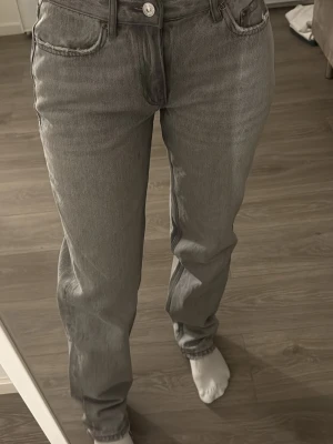 Grå raka jeans från gina - Säljer ett par grå jeans från gina med klassisk femficksmodell och raka ben. Jeansen har normal passform och är tillverkade i slitstarkt bomullsmaterial. Perfekta till en avslappnad stil och funkar året runt.