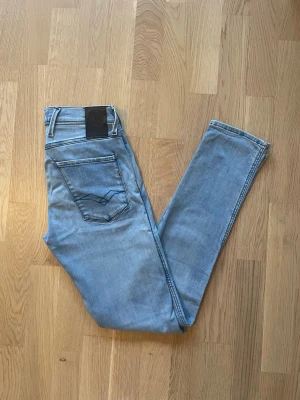 Ljusblå Replay Anbass jeans W28 L32 - Jag säljer dom här riktigt fräscha Replay Anbass jeansen som är i storlek W28 L32. De är knappt använda och är i superfint skick utan skador och defekter. Tveka inte att höra av er!                        Mått:  Längd=106cm Midja=37cm