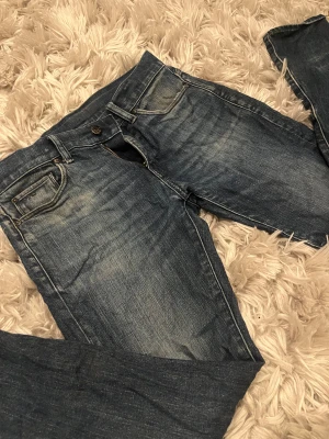 G-Star RAW 3301 Slim jeans blå - Snygga G-Star RAW 3301 Slim jeans i klassisk blå tvätt med slitningar och snygga detaljer. Modellen har fem fickor, dragkedja och knappstängning. Jeansen har en slim passform och är tillverkade i slitstarkt denimtyg.