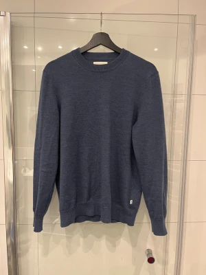 Mörkblå stickad tröja med rund hals - En snygg och stilren blå ull tröja från NN07 material: 100% ull tröjan är i mycket bra skick bara använd några få gånger! Nypris ligger på 1500
