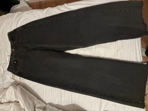 Svarta wide high waist jeans JJXX - Säljer ett par svarta jeans från JJXX med breda ben och hög midja. Modellen heter JXTokyo Wide RH HW och är tillverkad i svart denim. Klassisk femficksdesign och snyggt JJXX-märke bak i midjan. Perfekt för dig som gillar loose fit och trendig siluett.  Aldrig använda, prislappen sitter kvar, nypris 500kr