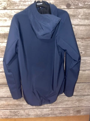 Mörkblå vindjacka Peak Performance - Snygg mörkblå vindjacka från Peak Performance med huva och hel dragkedja framtill. Jackan har två praktiska fickor med dragkedja och justerbar huva. Perfekt för blåsiga dagar och outdoor-aktiviteter. Stilren design med diskret logga på bröstet. (Priset är inte hugget i sten så förhandla gärna)