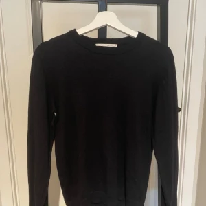 Mörkblå stickad tröja från A Day's March -  tröja från A Day's March i storlek M. färgen är navy/mörkblå . Tröjan har rund halsringning, ribbade muddar och lång ärm. Perfekt för lager-på-lager och enkel att matcha med allt i garderoben.  Kom gärna med prisförslag