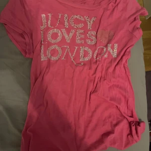 Juicy Couture rosa t-shirt med strass - Snygg rosa t-shirt från Juicy Couture med texten 'JUICY LOVES LONDON' på framsidan.