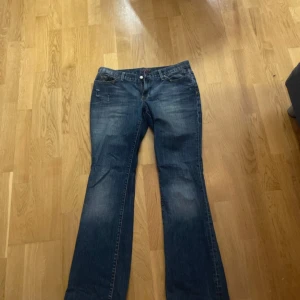Lågmidjade jeans - Snygga blå jeans med bootcut passform och coola broderade detaljer på bakfickorna. Köpa på vinted! Mått: midja-40, innerbenslängd-81