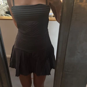 Svart plisserad kort klänning - Supersnygg klänning från meshki, storlek S och jättebra passform. Har dragkedja bak och man kan knyta i ryggen. Den är slut i alla storlekar på hemsidan, och nypris ligger på cirka 2000kr. Aldrig använd och prislappen kvar!