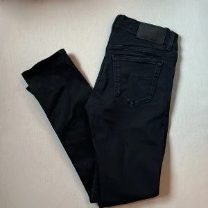 Tiger of Sweden slim fit - Svarta jeansbyxor från Tiger of Sweden i modellen Leon. Snygg, klassisk femficksdesign med svarta sömmar och läderpatch bak i midjan. Jeansen har en smal passform och är tillverkade i mjukt bomullsmaterial med stretch för extra komfort.