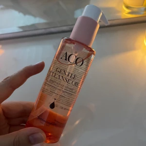 ACO Gentle Cleanse Oil rengöringsolja - ACO Gentle Cleanse Oil är en rengöringsolja i en genomskinlig pumpflaska med rosa detaljer. Oljan är lätt orangefärgad och passar alla hudtyper. Perfekt för att ta bort smink och orenheter på ett skonsamt sätt.