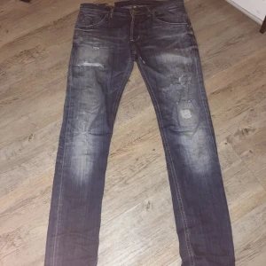 Dondup jeans - Säljer ett par blå jeans från Dondup med coola slitningar och patchade detaljer på benen. Jeansen har en snygg tvätt och är tillverkade i bomull för en skön känsla. Inga större defekter förutom lappen på insidan som är lite trasig men inget som syns. Pris kan diskuteras vid snabb affär 