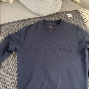 Mörkblå sweatshirt från Stenströms - Säljer en mörkblå sweatshirt från Stenströms med broderad logga framtill. Tröjan har rund halsringning, långa ärmar och är tillverkad i mjuk bomull. Perfekt för en avslappnad och stilren look. Nypris 2300kr