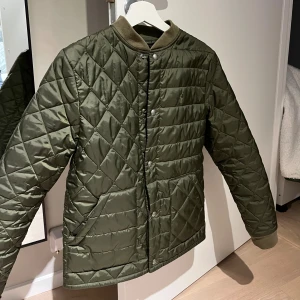 Stilren jacka Polo Ralph Lauren - Snygg olivgrön jacka från Polo Ralph Lauren med ribbad krage och tryckknappar framtill. Jackan har två fickor och diskret broderad logga på bröstet. Perfekt för dig som vill ha en stilren och fräsch lock! Perfekt till våren och hösten, eller en kall sommar dag🤷‍♂️