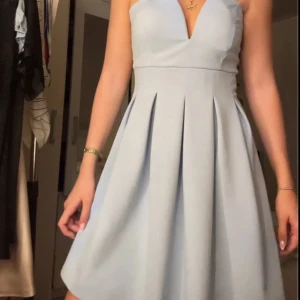 Ljusblå kort klänning från WalG - Superfin ljusblå klänning från WalG. Kjolen är veckad och har en snygg, utsvängd form som ger en elegant siluett. Perfekt för dig som vill sticka ut med en stilren look.